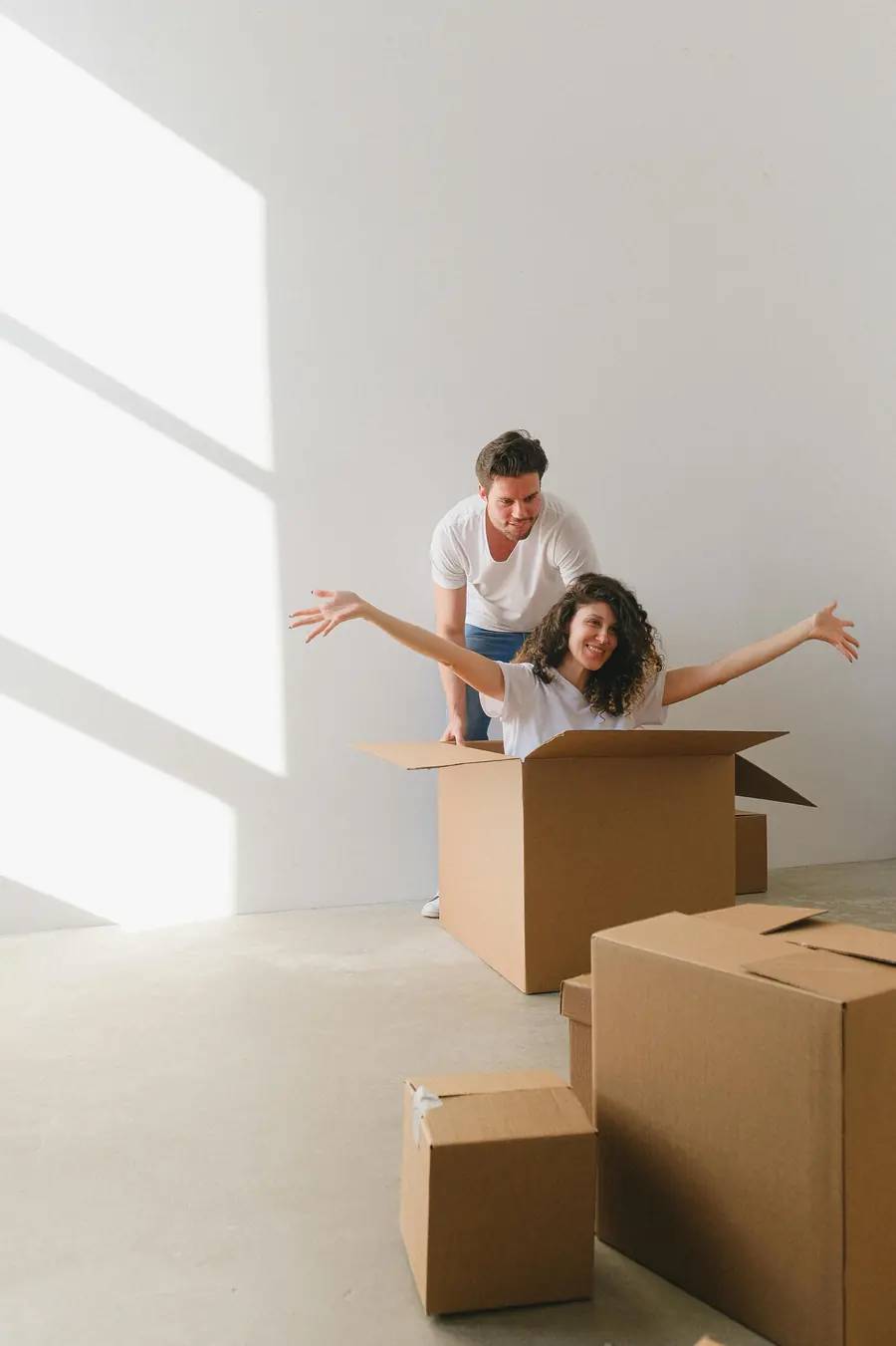 Umzug in Bayern: Paar packt in der neuen Wohnung Umzugskartons aus